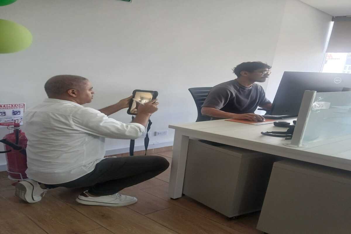 Consultor de SO&NSO realizando una evaluación ergonómica de puesto de trabajo en oficina para prevenir lesiones osteomusculares.